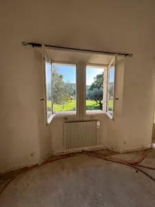 Chambre avant travaux, sols bruts et réseaux plomberie apparents, rénovation villa Alpilles