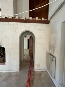Grand salon double hauteur en cours de rénovation, murs pierre calcaire et cheminée, Les Baux de Provence