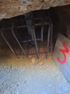 Fouille en sous oeuvre révélant l'armature existante d'une semelle de fondation, avant injection de coulis de ciment, sinistre sécheresse Var
